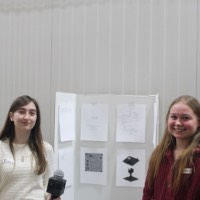 Two students holding a microphone.